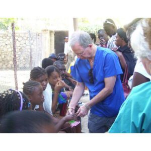 A picture of the donor giving food to the kids
