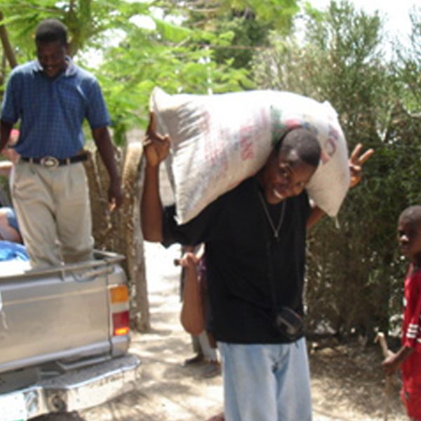 A picture of the boy carrying the rice bag on his back