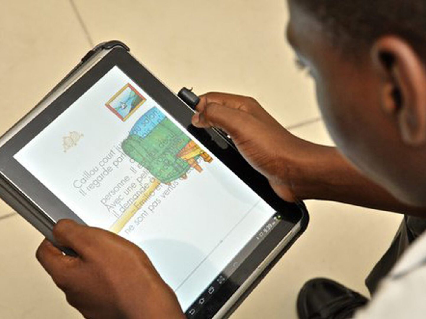 Tablet Program 2 A picture of the school boy reading from the tablet