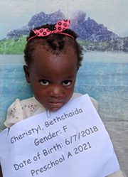 A little girl holding up a sign that says gender f.