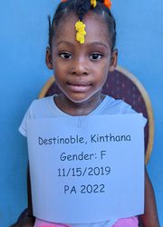 A little girl holding up a sign that says destinable kittyna gender f.