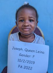 A little girl holding up a sign that says joseph queen lena gender f.