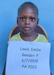 A young girl holding up a sign that says louis emily gender f.