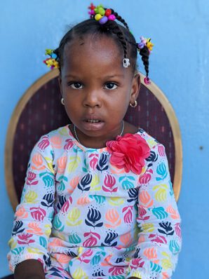 A young girl with curly hairs looking at camera