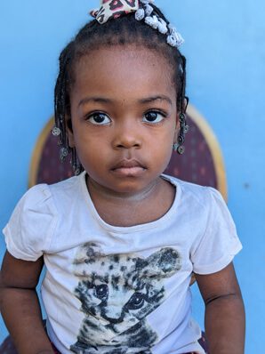 A young girl sitting and looking at camera