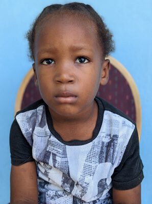 A young boy sitting and looking at camera